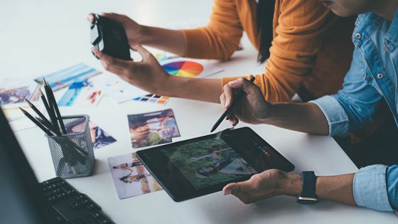 two people lean over a table and review their brand style.